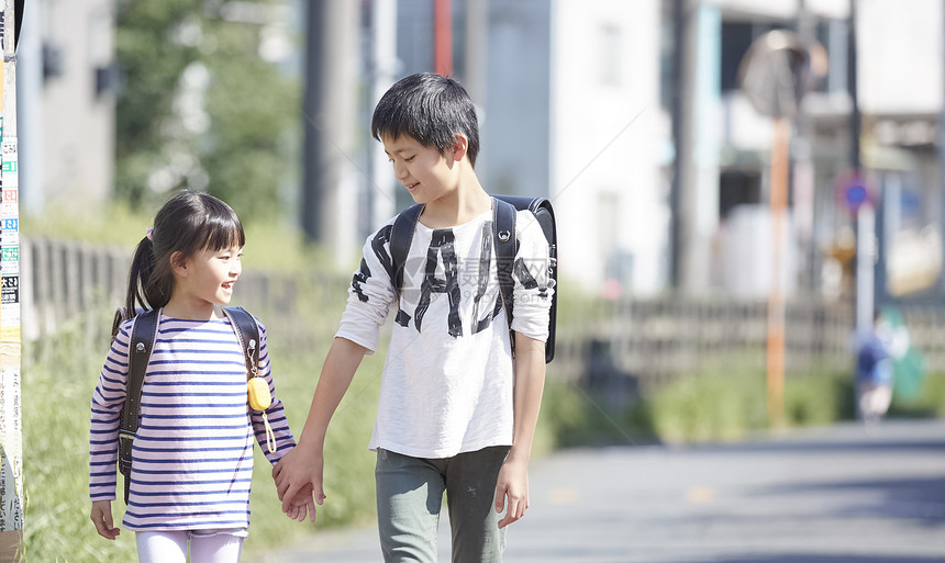 牵着妹妹一起上学的小男孩图片