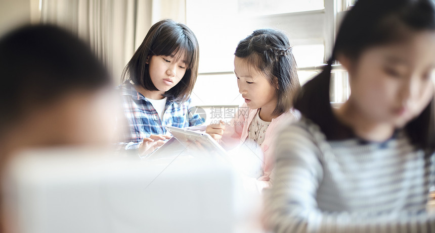 小学生使用平板电脑学习讨论图片