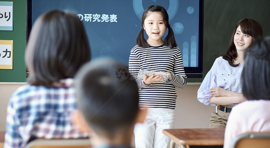 小学生在老师的指导下学习平板电脑使用知识图片