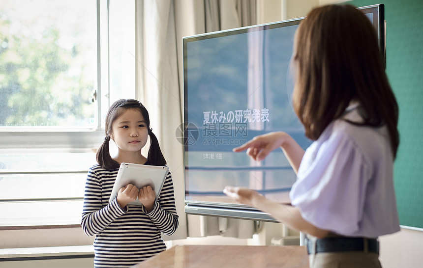 小学生在老师的指导下学习平板电脑使用知识图片