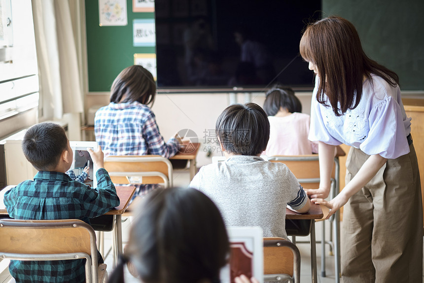 小学生在老师的指导下学习电脑使用知识图片