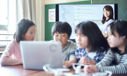 老师陪孩子使用电脑小学生在老师的指导下学习电脑使用知识背景