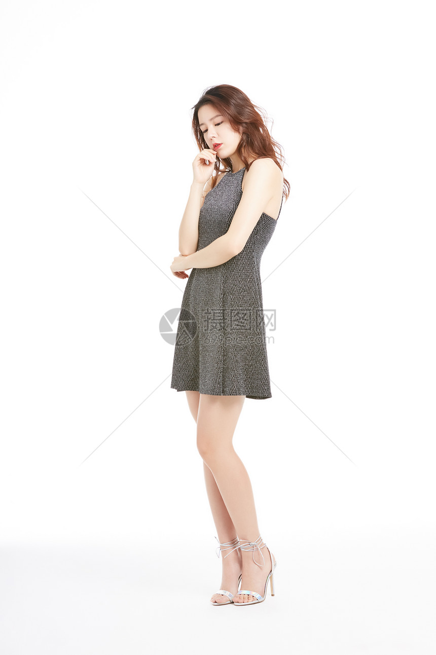 穿着连衣裙低头思考的年轻女性图片