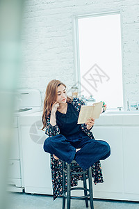 坐在凳子上的女人看书图片