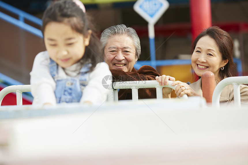 在游乐园里的老年夫妇带着孙女游玩图片