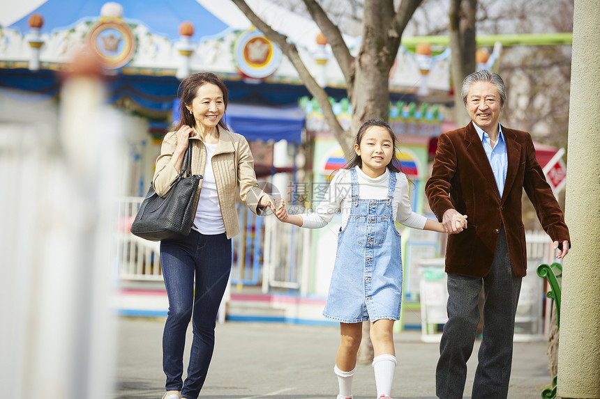 在游乐园里的老年夫妇带着孙女游玩图片