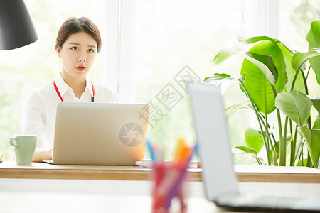 办公室使用笔记本电脑办公的职业女性图片
