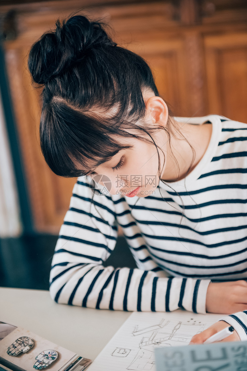 研究生院年轻女诊断在图书馆学习的妇女图片