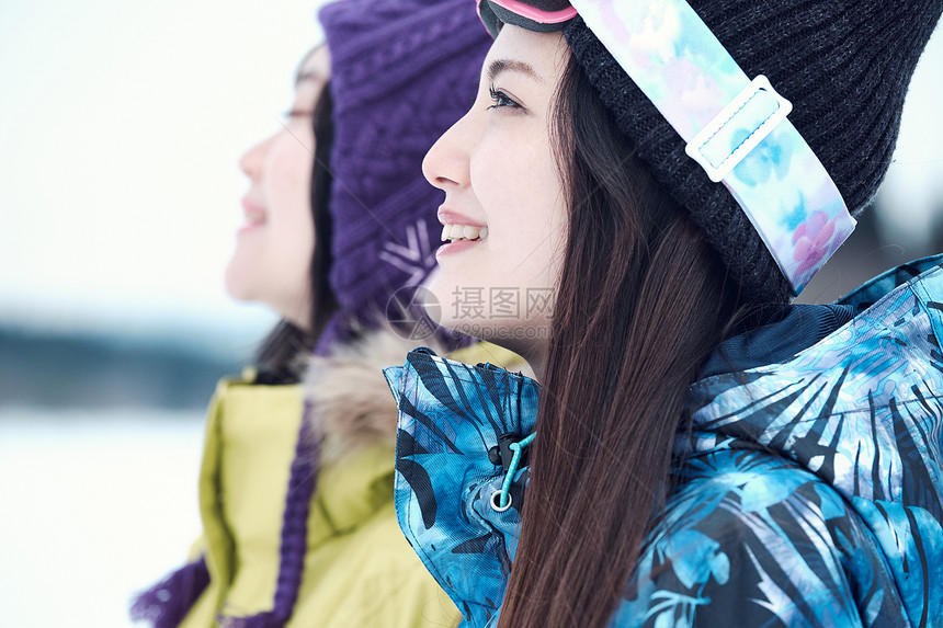 愉快的女人和朋友在滑雪图片
