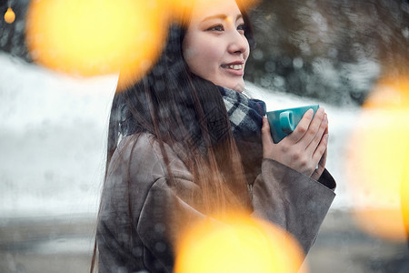 年轻轻松彩灯享受在雪的妇女茶时间高清图片