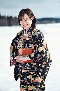 日本人穿着和服过年站立在雪的和服妇女图片