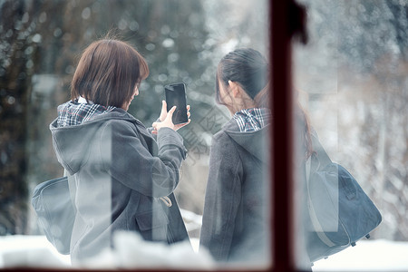 放学女生智能手机高中女孩在多雪的图片
