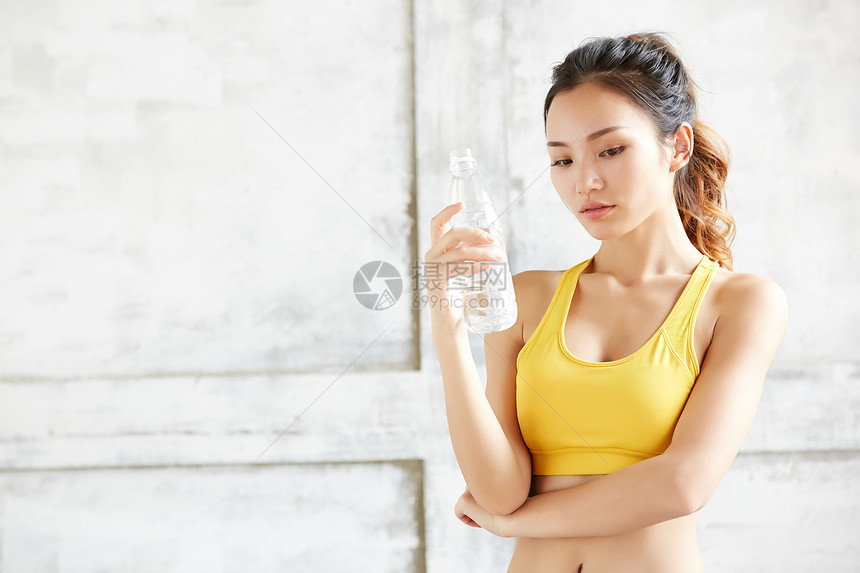 穿着运动服装拿着水瓶的女青年图片