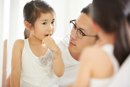 父亲贴心照顾可爱的小女儿刷牙背景图片