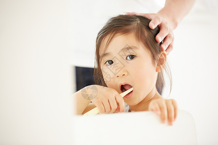 父亲贴心照顾可爱的小女儿刷牙背景图片