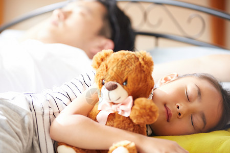 没睡好小朋友抱着熊娃娃睡觉背景