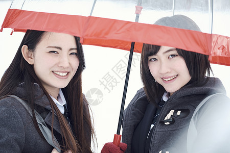 站在雪地上聊天的女高中生图片