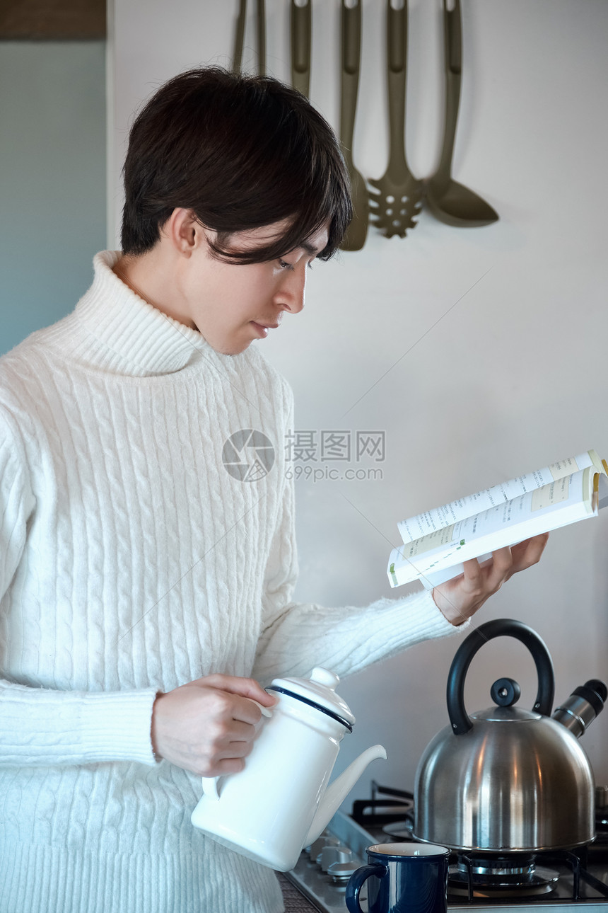 户内在厨房里看书的男子图片