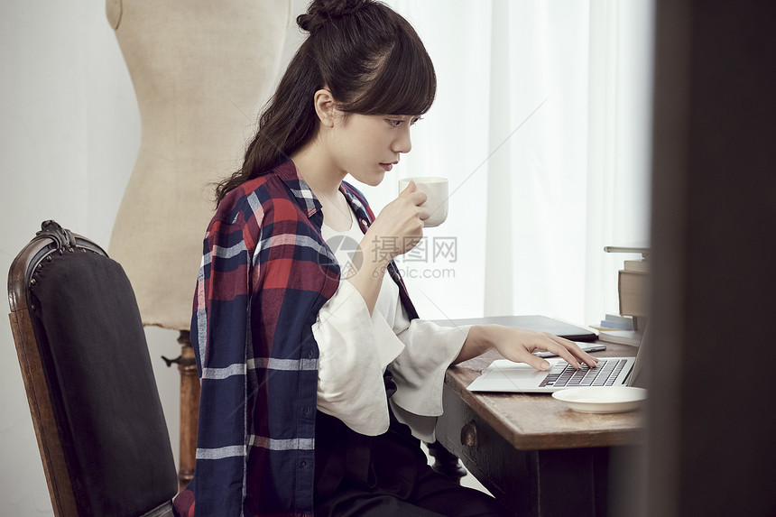 居家办公喝咖啡的年轻女子图片
