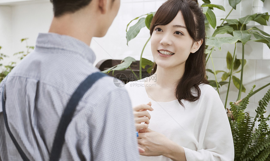 室内盆栽青年男人和女人在一家花店图片