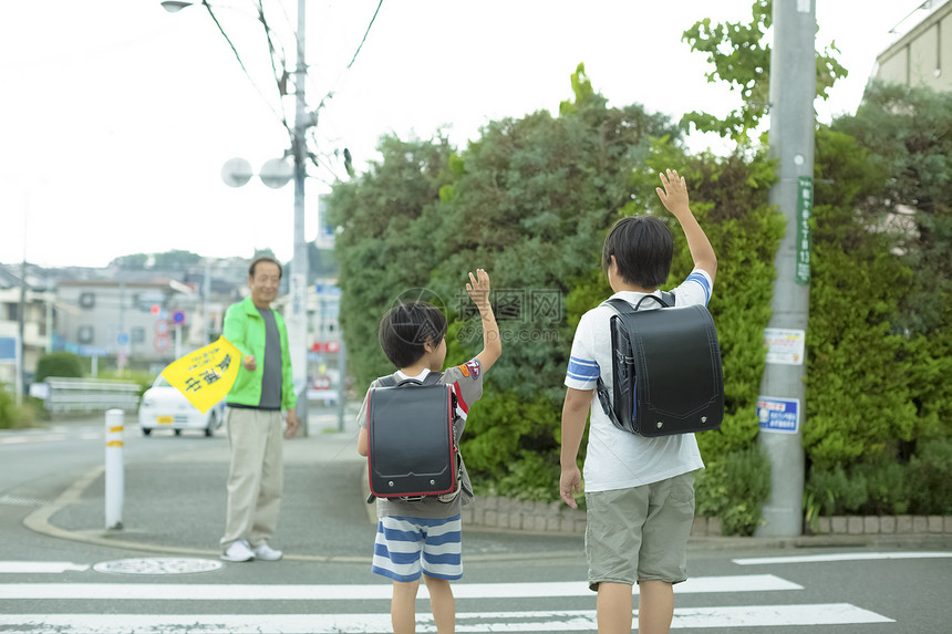 老年人指导小学生去学校过马路图片