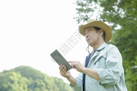 农民老人使用笔记本电脑背景图片