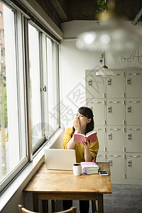 坐在咖啡馆学习的女性图片