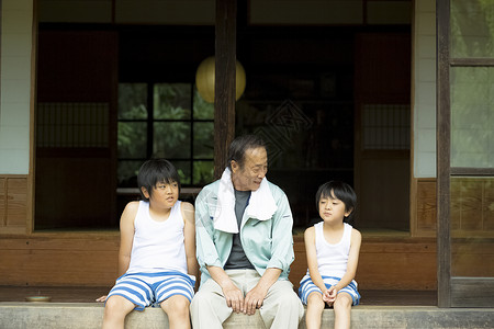坐在庭院外休息的祖孙三人图片