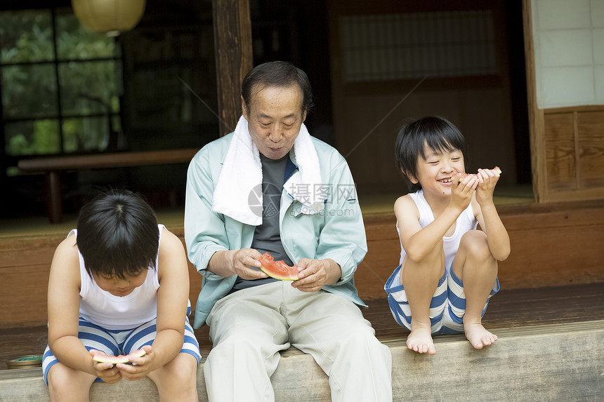 坐在户外吃西瓜的爷爷和孙子图片