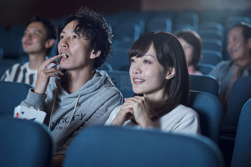 女人男外出观看电影的观众在电影院图片