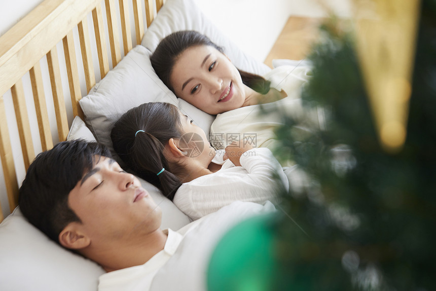 特写镜头幸福的一家人在床上休息图片
