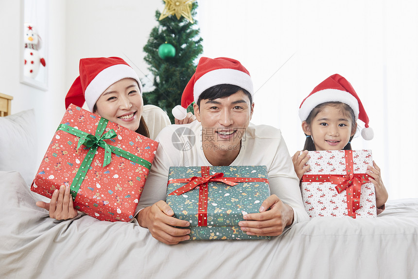 拿着圣诞礼物盒开心的一家三口图片