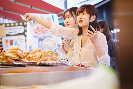 年轻女闺蜜一起逛美食街图片