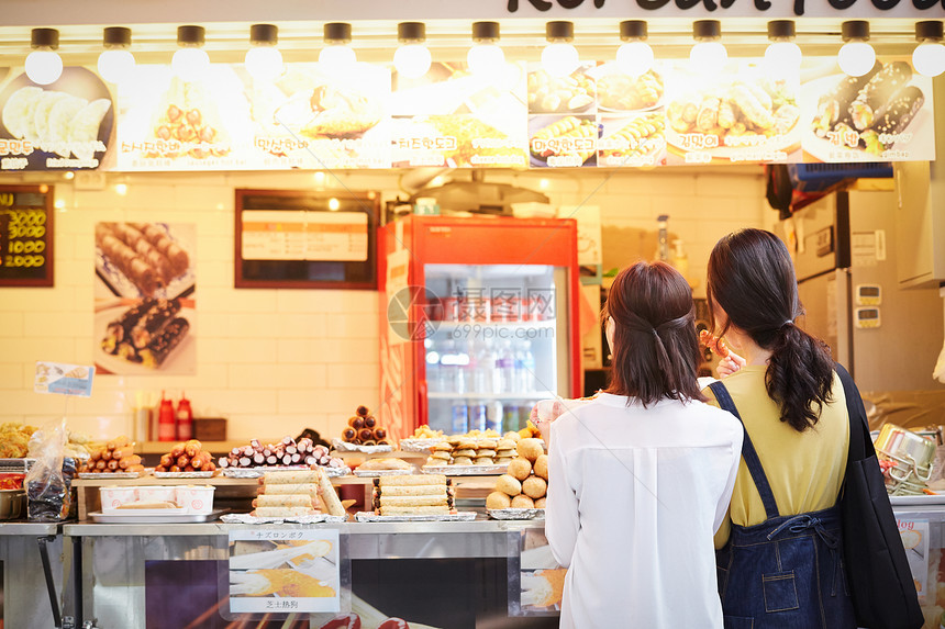 女孩们时髦休息韩国女旅游街头食品图片