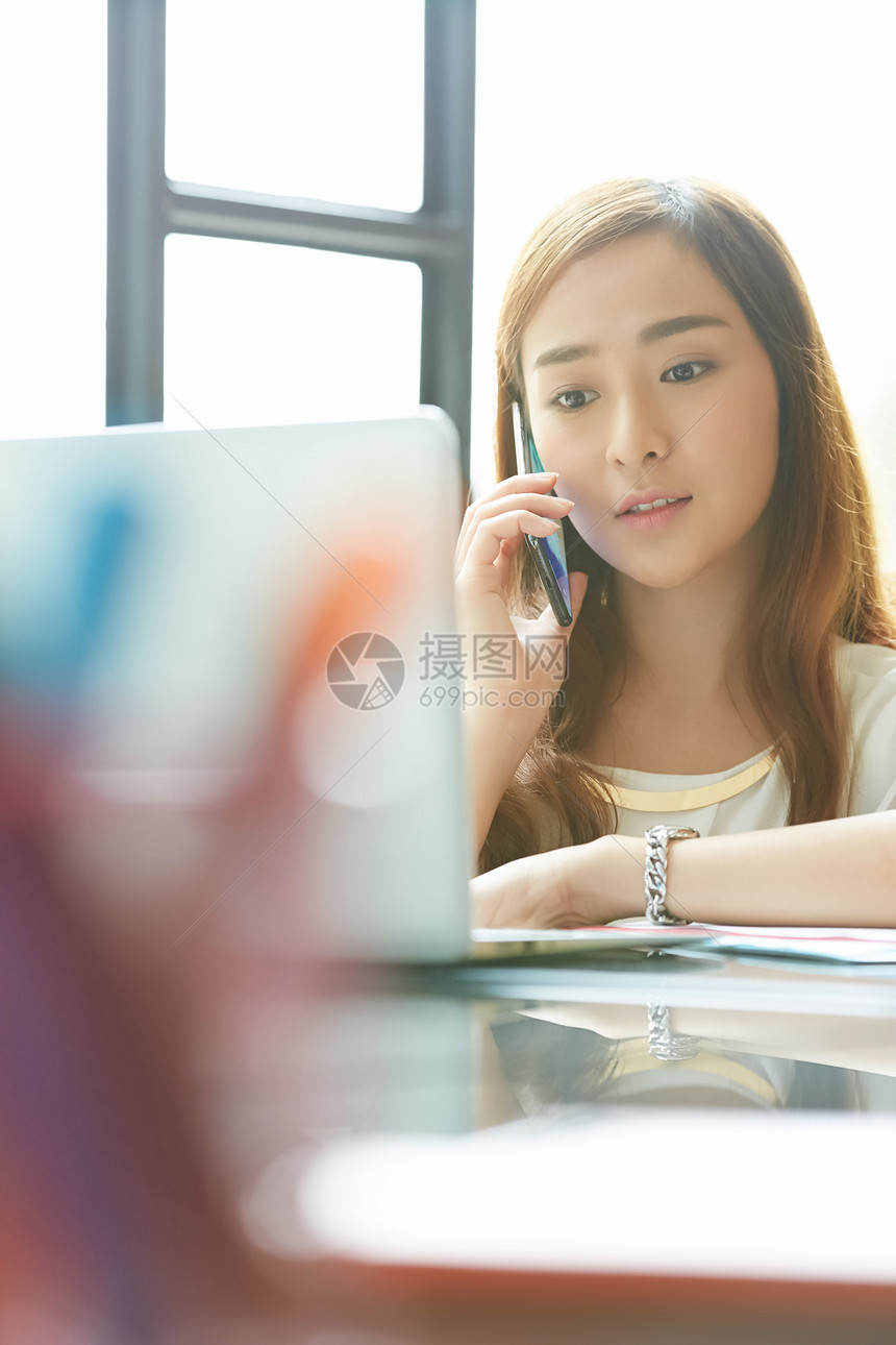 办公室女人在书桌上工作打电话图片