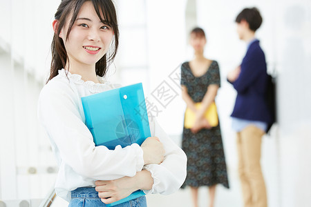 校园里拿着文件袋的青春少女背景图片