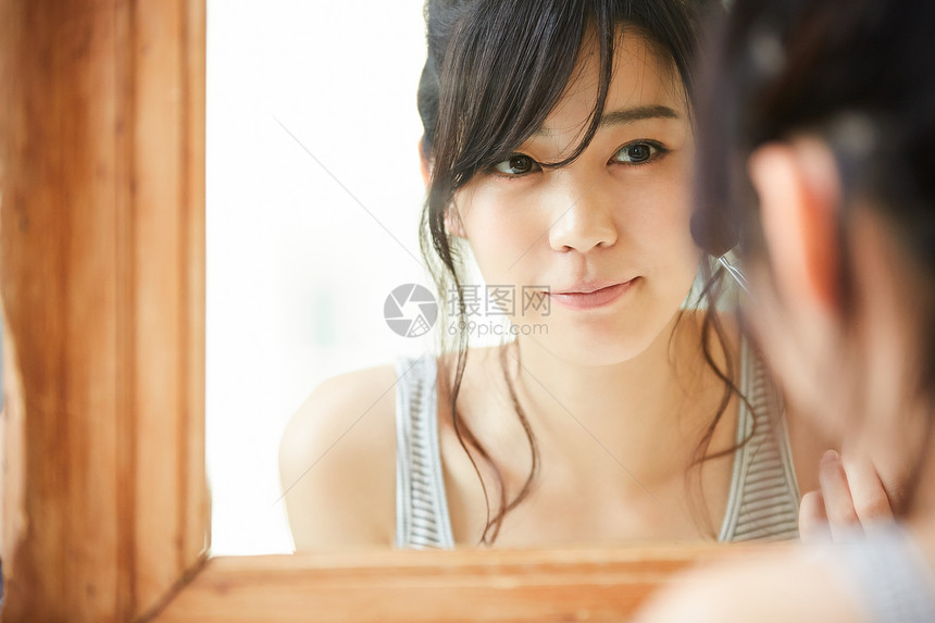 对着镜子微笑的女青年图片