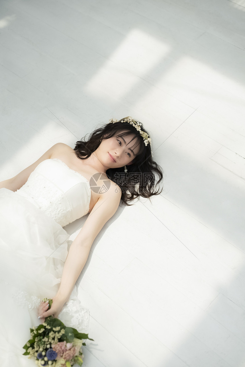 躺在地上穿着婚纱的女性图片