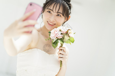 新娘拿着手捧花自拍微笑图片