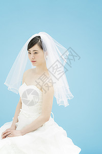 穿着婚纱佩戴头纱的新娘蓝色背景图片