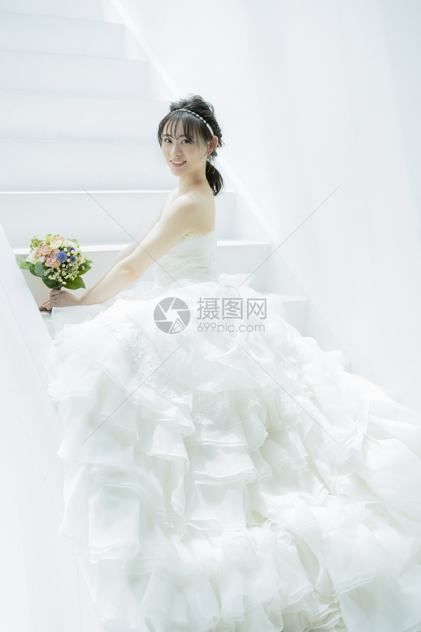 坐在台阶上拿着手捧花的新娘图片