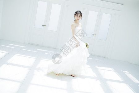 年轻女子提起婚纱的裙摆转圈背景图片