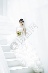 台阶上穿着婚纱拿着手捧花的新娘图片