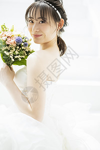 穿着婚纱拿着捧花微笑的新娘图片