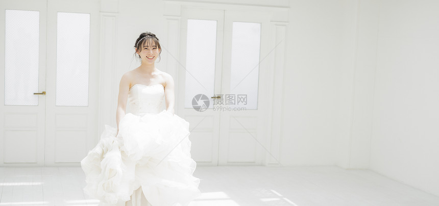 新娘提起婚纱的裙摆微笑图片