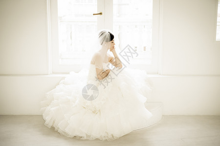 穿着婚纱坐着思考的新娘图片