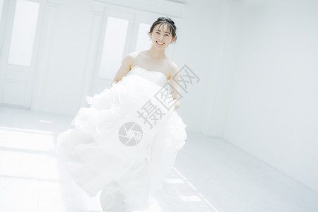 新娘提起婚纱的裙摆奔跑图片