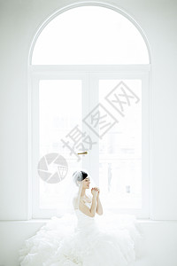 穿着婚纱坐在窗边起到的新娘图片