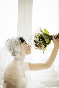 拿着手捧花闻的新娘图片