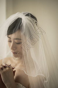 头戴头纱祈祷的新娘特写图片